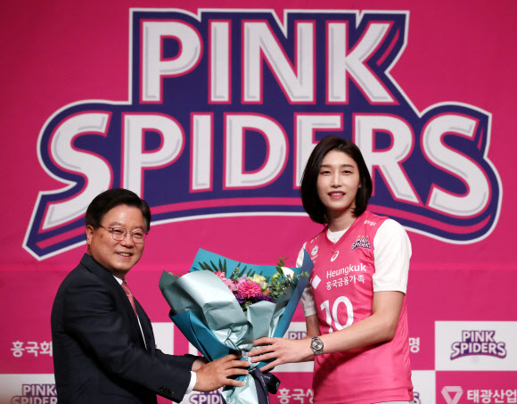 11년 만에 국내 프로배구 V리그로 복귀한 김연경이 10일 오후 서울 중구 밀레니엄 힐튼 호텔에서 열린 흥국생명 배구단 입단 기자회견에서 유니폼을 착용한 후 구단주 조병익 흥국생명보험 대표이사으로부터 꽃다발을 받고 있다. 2020.6.10  연합뉴스