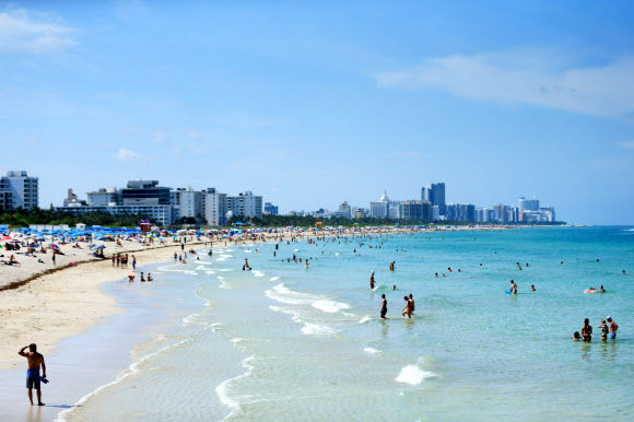 미국 플로리다 주민들이 10일(현지시간) 코로나19 여파로 3개월여 문을 닫았다 재개방한 마이애미 비치 바닷가에서 수영을 즐기며 휴식을 취하고 있다. 게티/AFP 연합뉴스