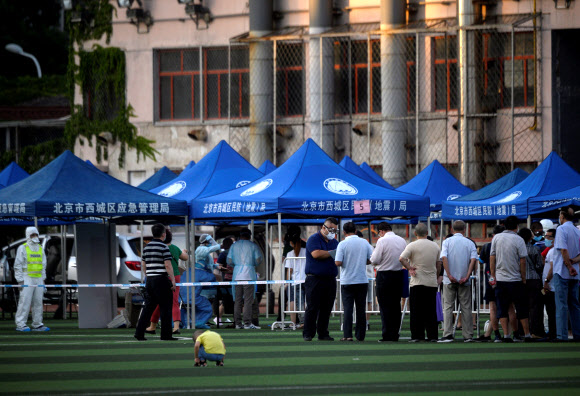 중국 베이징에서 코로나19 바이러스가 발병한 신파디 시장 방문자들이 14일 코로나 검사를 받고 있다. 연합뉴스