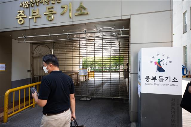 15일 서울 중구 서울중앙지방법원 중부등기소 찾은 시민들이 신종 코로나바이러스 감염증(코로나19) 확진자 발생으로 폐쇄된 등기국을 보며 발길을 돌리고 있다. 중앙지법은 중부등기소 소속 직원이 14일밤 10시쯤 코로나19 양성판정을 받았다고 밝히며 15일 폐쇄했다. 등기 관련 접수업무는 서초구에 위치한 중앙지법 등기국에서 처리할 예정이다. 2020.6.15 뉴스1