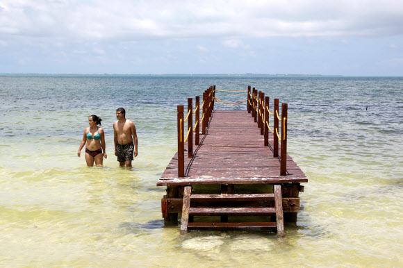 14일(현지시간) 멕시코 칸쿤을 찾은 관광객들이 바닷가에서 수영을 하며 여가를 즐기고 있다. 로이터 연합뉴스