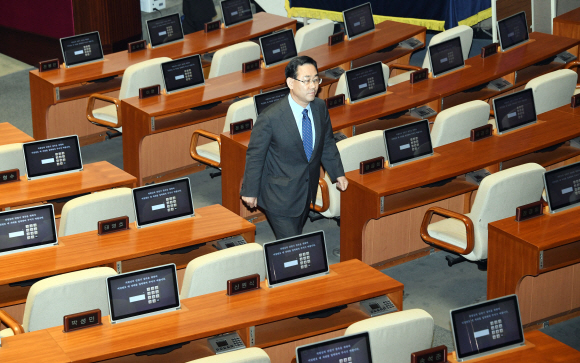 15일 홀로 본회의장에 들어온 통합당 주호영 원내대표가 의사진행 발언을 마친 뒤 회의에 불참한 의원들의 빈 좌석을 지나는 모습. 정연호 기자 tpgod@seoul.co.kr