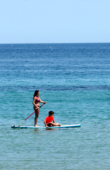 16일 강원 양양군 죽도해변에서 외국인 관광객들이 패들보드를 타고 있다. 2020.6.16  연합뉴스