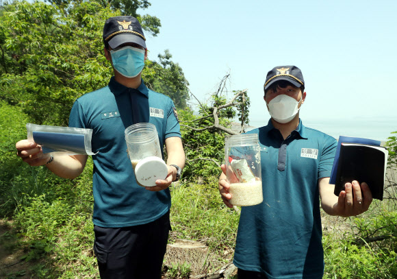 탈북민단체가 쌀 페트(PET)병을 북측에 보내겠다며 살포를 예고한 가운데 16일 오전 인천시 강화군 석모도 한 해안가에서 경찰이 과거 선교단체가 살포한 것으로 추정되는 쌀 페트병과 성경책 등을 수거하고 있다. 2020.6.16  연합뉴스
