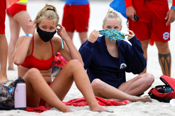 15일(현지시간) 미국 캘리포니아주 샌디에이고에서 코로나19로 폐장됐던 해수욕장이 재개장하자 인명구조요원 훈련 프로그램 참가자들이 마스크를 착용하고 있다. 로이터 연합뉴스