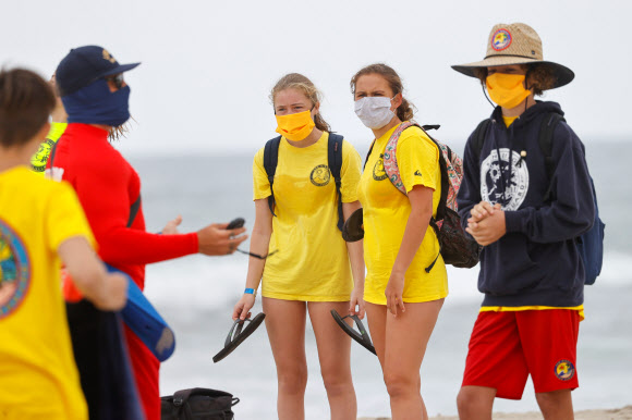 15일(현지시간) 미국 캘리포니아주 샌디에이고에서 코로나19로 폐장됐던 해수욕장이 재개장하자 인명구조요원 훈련 프로그램 참가자들이 마스크를 착용하고 훈련에 임하고 있다. 로이터 연합뉴스