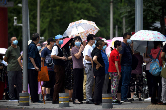 코로나19 재유행으로 혼란에 휩싸인 중국 베이징에서 16일 신파디 도매시장 이근 주민들이 핵산 검사를 받기 위해 줄을 서서 기다리고 있다. 베이징 AFP 연합뉴스