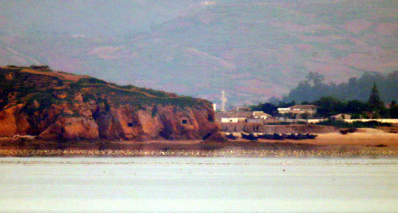 북한이 금강산 관광지구와 개성공단, 비무장지대(DMZ) 내 감시초소(GP)에 군부대를 재주둔시키겠다고 밝힌 17일 오전 인천시 옹진군 대연평도 망향전망대에서 바라본 북한 개머리 해안의 일부 포진지가 개방돼 있다.  연평부대 관계자 확인 결과 해당 포진지는 현재 사용하지 않는 것으로 확인됐다. 2020.6.17  연합뉴스