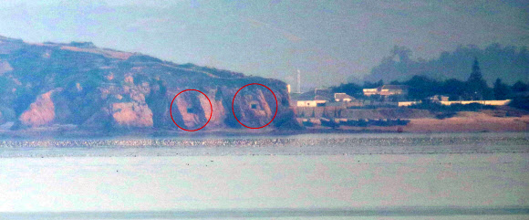 북한이 금강산 관광지구와 개성공단, 비무장지대(DMZ) 내 감시초소(GP)에 군부대를 재주둔시키겠다고 밝힌 17일 오전 인천시 옹진군 대연평도 망향전망대에서 바라본 북한 해안의 일부 포진지가 개방돼 있다.  연평부대 관계자 확인 결과 해당 포진지는 현재 사용하지 않는 것으로 확인됐다. 2020.6.17  연합뉴스