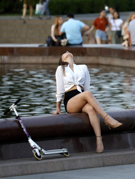 한 여성이 16일(현지시간) 러시아 모스크바의 분수대에 앉아서 휴식을 취하고 있다. 타스 연합뉴스