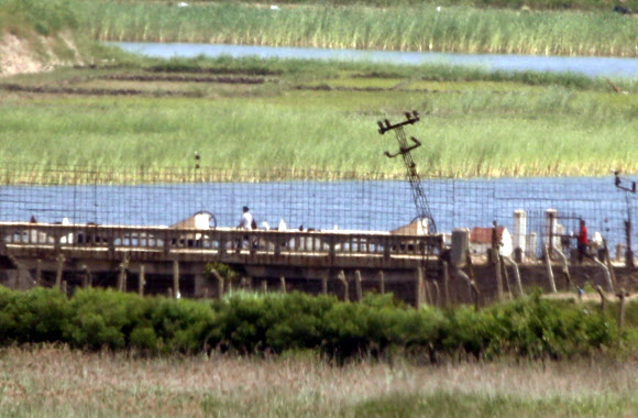 17일 인천시 강화군 평화전망대에서 바라 본 북한 황해북도 개풍군 마을에서 북한 주민들이 길을 걷고 있다. 북한은 지난 16일 개성 남북공동연락사무소를 폭파했다. 2020.6.17  연합뉴스