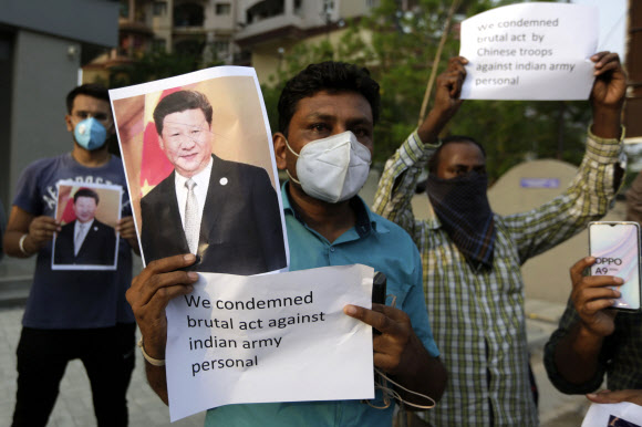 인도 아메다바드에서 16일(현지시간) 시위대가 시진핑 중국 국가주석의 사진을 들고 중국과의 국경충돌로 인도 군인들이 사망한 사건에 항의하고 있다. 2020-06-17 아메다바드 연합뉴스