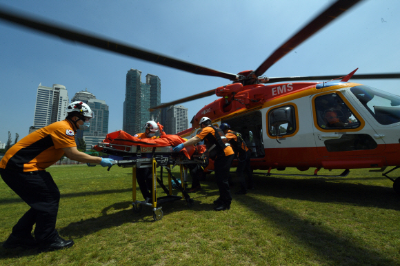 헬기장이 있는 보라매공원에서 지상구급대원들이 관악산에서 구조한 환자를 인계받고 있다.
