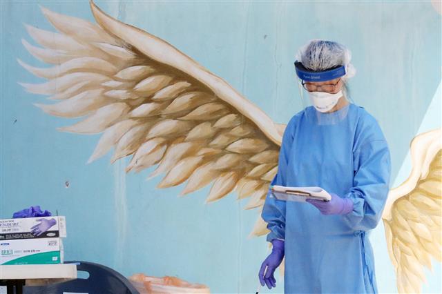 19일 오전 경기도 안산시 와동초등학교에서 한 의료진이 학생들의 신종 코로나바이러스 감염증(코로나19) 검사를 위해 대기하고 있다. 지난 17일 와동초등학교를 다니는 A군이 코로나19 확진 판정을 받아 이 학교 학생과 교직원 등 788명에 대한 전수 검사가 실시됐다. 2020.6.19 뉴스1