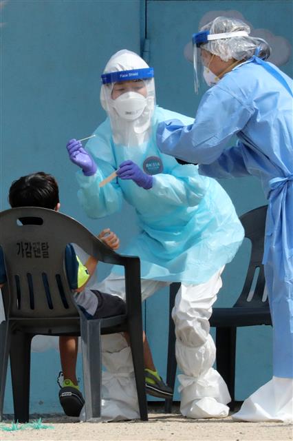 19일 오전 경기도 안산시 와동초등학교에서 학생들이 신종 코로나바이러스 감염증(코로나19) 검사를 받고 있다. 지난 17일 와동초등학교를 다니는 A군이 코로나19 확진 판정을 받아 이 학교 학생과 교직원 등 788명에 대한 전수 검사가 실시됐다. 2020.6.19 뉴스1