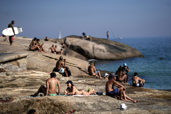 코로나19 확산이 가속되는 가운데 20일(현지시간) 브라질 리우데자네이루의 아르포아도르 해변에서 사람들이 일광욕을 즐기고 있다. AP 연합뉴스