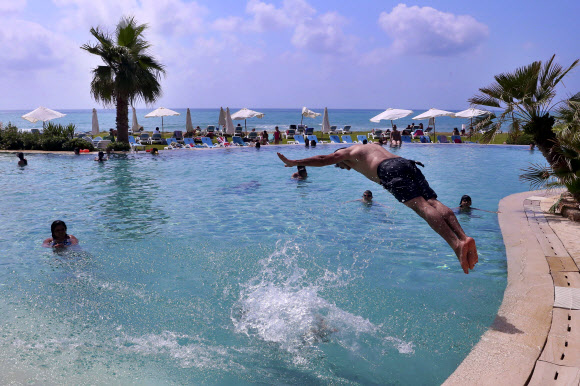 20일(현지시간) 레바논 베이루트 남쪽에 있는 라구아바 리조트 수영장에서 관광객들이 물놀이를 즐기고 있다. AP 연합뉴스
