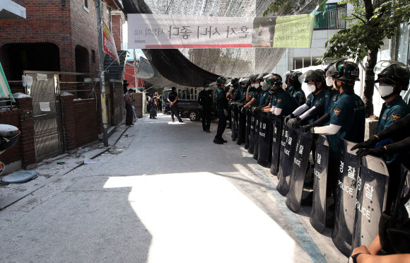 경찰과 용역업체 직원들이 22일 오전 서울 성북구 장위동 사랑제일교회 앞에서 법원의 명도집행을 위해 대기하고 있다.2020.6.22  연합뉴스