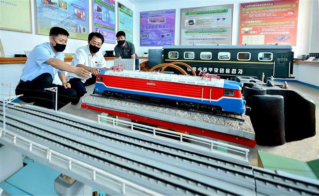 북한 노동당 기관지 노동신문은 23일 철도성 철도연구원들을 소개하며 “철도의 현대화 실현을 위한 연구사업에 지혜를 합쳐가고 있다”라고 전했다. 사진은 마스크를 낀 채 토의를 하는 철도성 철도연구원들의 모습.  평양 노동신문=뉴스1