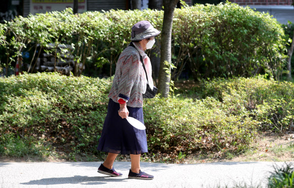 전국적으로 무더운 날씨가 이어지는 23일 오전 서울 마포구 경의선 숲길에서 한 시민이 부채를 들고 산책을 하고 있다. 2020.6.23  연합뉴스