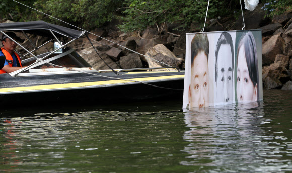 지난 22일 밤 경기 파주에서 탈북단체가 보낸 대북전단 살포용 풍선이 23일 홍천군 서면 마곡리 인근 야산에 떨어져 경찰이 수거하고 있다. 발견된 대북전단 살포용 풍선은 2∼3m 크기로, 김정은 북한 국무위원장 일가의 사진이 부착돼 있다. 2020.6.23  연합뉴스