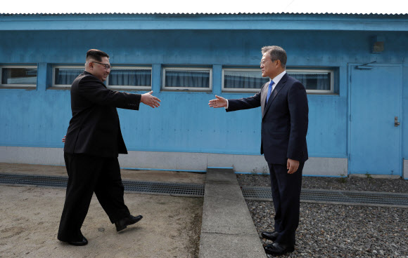 문재인 대통령과 김정은 북한 국무위원장이 27일 판문점 군사분계선을 사이에 두고 악수하고 있다. 2018.4.27 연합뉴스