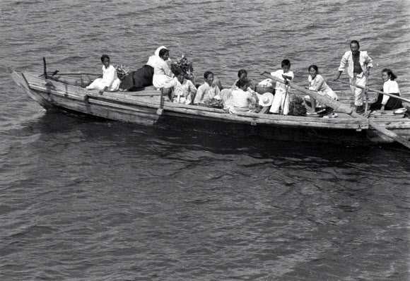 나룻배 이용해 강을 건너는 피난민들