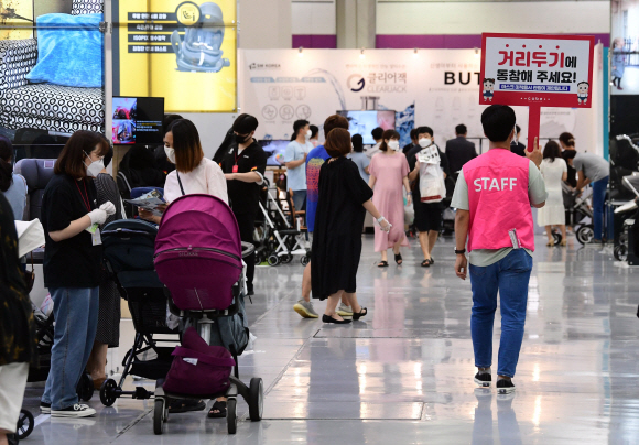 25일 서울 강남구 삼성동 코엑스에서 열린 제31회 코베 베이비페어에서 한 직원이 거리두기 동참을 독려하는 피켓을 들고 행사장을 돌아다니고 있다.  2020.6.25  정연호 기자 tpgod@seoul.co.kr