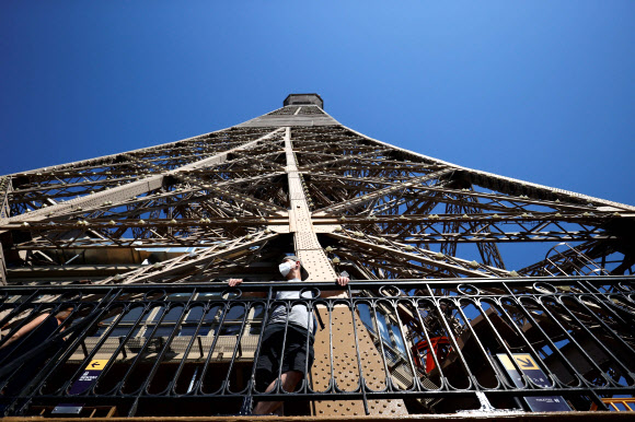 마스크를 쓴 방문객이 25일 부분적으로 재개장한 프랑스 파리 에펠탑에 올랐다. 연합뉴스.
