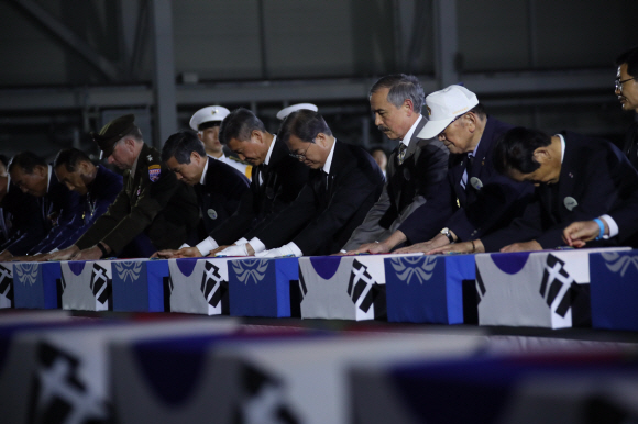 문재인 대통령이 25일 서울공항에서 열린 6·25전쟁 70주년 행사에서 국군 전사자들의 유해에 참전기장을 수여한 뒤 묵념하고 있다. 도준석 기자 pado@seoul.co.kr