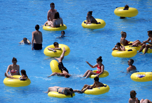 27일(현지시간) 벨라루스 민스크에 위치한 워터파크 ‘드림랜드’에서 사람들이 물놀이를 즐기고 있다. EPA 연합뉴스