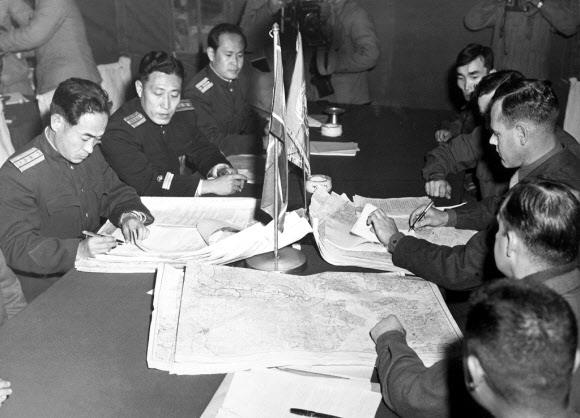 북한이 군사행동을 잠시 보류하자 여권에선 6·25전쟁의 종전을 추진하는 움직임이 시작됐다. 사진은 1951년 10월 11일 판문점에서 열린 정전회담에서 유엔군의 머리(오른쪽) 대령과 북한 인민군의 장춘산 대령이 비무장지대의 남북군사분계선에 대해 가조인하고 있는 모습. 정전협정은 1953년 7월 유엔군과 북한, 중국 사이에 체결됐다.
