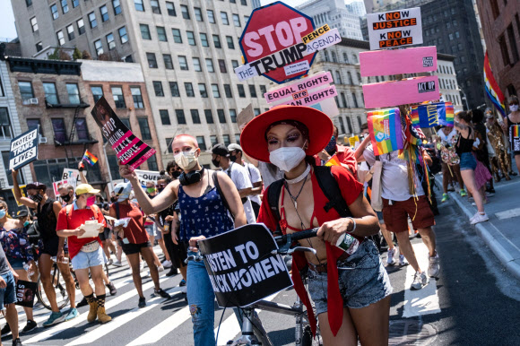 28일(현지시간) 미국 뉴욕에서 성소수자들의 ‘프라이드 퍼레이드’가 열린 가운데 참가자들이 마스크를 쓴채 행진하고 있다. 게티/AFP 연합뉴스
