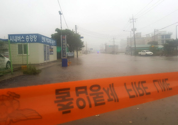 영동지방을 중심으로 많은 비가 예보된 30일 오전 강원 강릉시 안목 커피거리 승강장 인근 도로가 밤새 내린 비로 잠겨 통제돼 있다. 2020.6.30  연합뉴스
