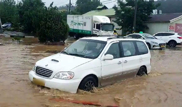 영동지방을 중심으로 많은 비가 예보된 30일 오전 강원 강릉시의 한 도로에서 차량이 고인 빗물을 헤치며 서행하고 있다. 2020.6.30  연합뉴스