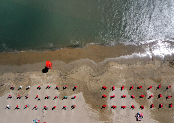 부산지역 7개 해수욕장 정식 개장을 하루 앞둔 30일 오후 부산 사하구 다대포해수욕장에서 파라솔이 설치되고 있다. 다대포 해수욕장은 파라솔 간 2∼4m 간격을 두고 운영된다. 2020.6.30  연합뉴스
