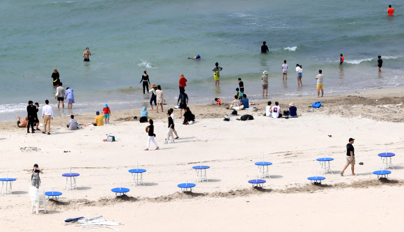 제주도 내 해수욕장의 공식개장을 하루 앞둔 30일 오후 제주시 조천읍 함덕해수욕장에서 관계자들이 파라솔 테이블을 설치하고 있다. 2020.6.30  연합뉴스