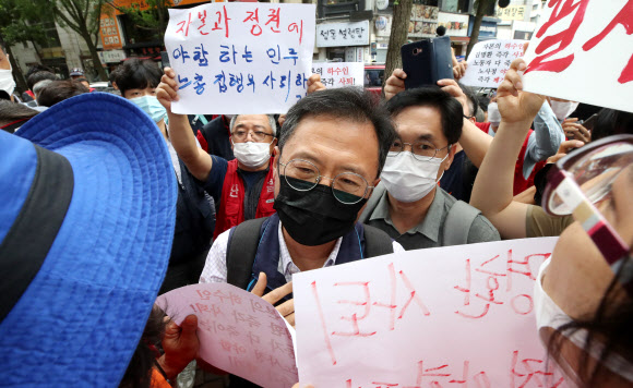 1일 오전 서울 중구 정동 전국민주노동조합총연맹 앞에서 노사정 합의에 반대하는 민노총 조합원들이 건물로 들어서는 김명환 위원장을 가로막고 있다. 2020.7.1  연합뉴스