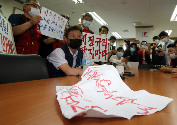 1일 오전 서울 중구 전국민주노동조합총연맹 위원장실에서 김명환 민주노총 위원장이 중앙집행위원회 회의장으로 향하다 노사정 합의에 반대하는 민주노총 비정규직 조합원 등과 대화하고 있다.  2020.7.1  연합뉴스