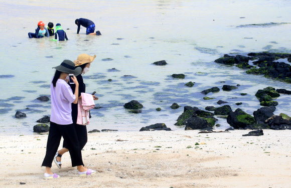 제주도 지정해수욕장 11곳이 일제히 개장한 1일 오전 제주시 금능해수욕장을 찾은 피서객들이 물놀이를 즐기고 있다. 2020.7.1  연합뉴스