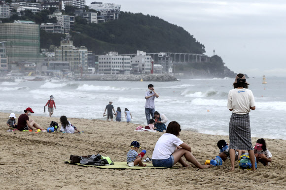 1일 개장한 부산 해운대 해수욕장을 찾은 피서객들이 높은 파도로 수영이 금지되자 백사장에서 아쉬움을 달래고 있다. 2020.7.1  연합뉴스