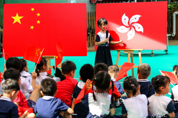 1일 홍콩 주권 반환 23주년을 맞이한 가운데 중국 광둥성 선전시의 한 유치원에서 중국 어린이가 중국과 홍콩의 국기를 소개하고 있다.  AFP 연합뉴스