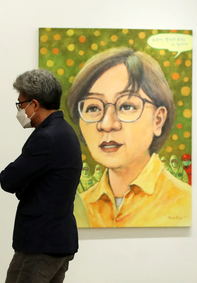 1일 서울 종로구 학고재 갤러리에서 열린 전시 ‘그림과 말 2020’ 간담회에서 참석자가 박재동 작가가 정은경 질병관리 본부장을 그린 작품 ‘바이러스2’를 살펴보고 있다. ‘현실과 발언’ 동인 16명이 참여하는 이번 전시는 오는 31일까지 학고재 전관에서 열린다. 2020.7.1  연합뉴스