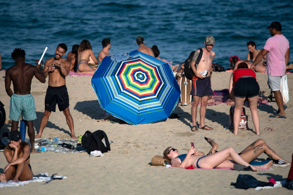 1일(현지시간) 스페인 바르셀로나의 엘 보가텔 해변에서 시민들이 일광욕을 즐기고 있다. AFP 연합뉴스