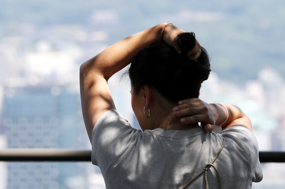 3일 오전 서울 용산구 남산에서 한 시민이 머리카락을 올려 더위를 식히고 있다. 2020.7.3 연합뉴스