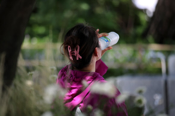 3일 오전 서울 용산구 남산에서 한 시민이 얼음물을 마시고 있다. 2020.7.3 연합뉴스
