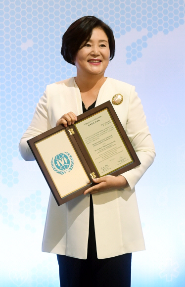 김정숙 여사가 8일 오전 서울 관악구 국제백신연구소(IVI)에서 열린 ‘IVI 연대?협력의 날 - 백신, 한 방울의 기적’ 행사에서 명예회장 추대패를 받은 뒤 기념촬영을 하고 있다. 2020. 7. 8 도준석 기자pado@seoul.co.kr