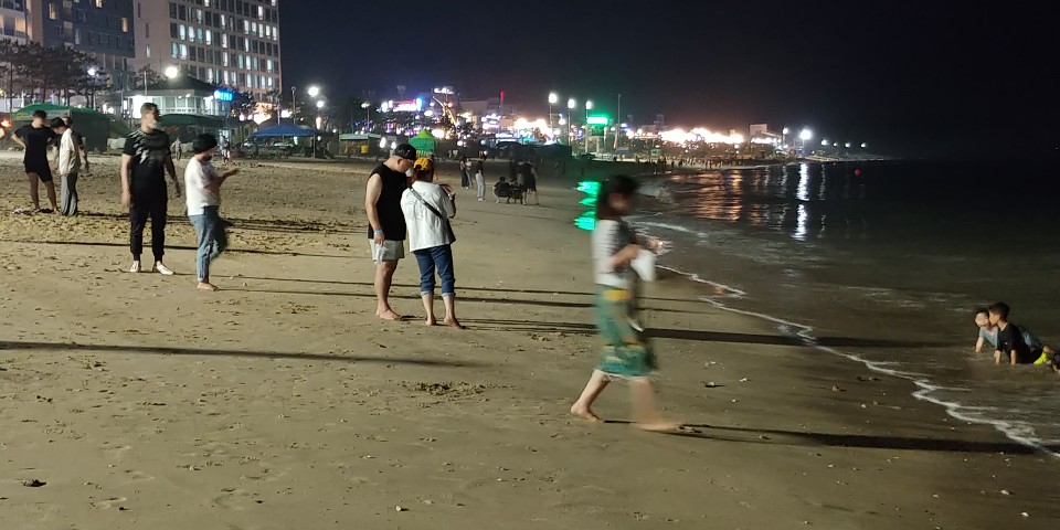 지난 11일 밤 충남 보령 대천해수욕장에서 아이들이 바닷물에 들어가 물놀이를 하는 가운데 피서객들이 백사장을 걸으며 밤바다를 즐기고 있다.