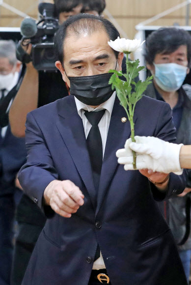 탈북민 출신 미래통합당 태영호 의원이 12일 빈소에 헌화하기 위해 꽃을 건네받고 있다.  연합뉴스