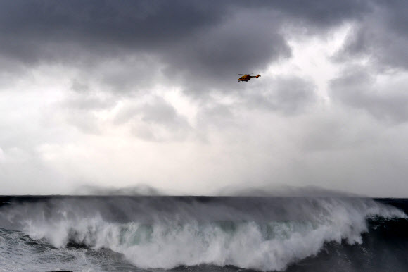 서프 라이프 구조 헬기가 15일(현지시간) 호주 시드니 쿠지비치 주변 해안에서 실종된 서퍼를 수색하고 있다. EPA 연합뉴스